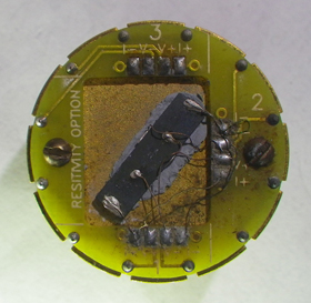 Researchers at Caltech devised a way to calculate the electrical properties of individual components of a composite material by testing the material’s response in a range of magnetic fields. This image shows the material wired in a sample holder designed to measure its electrical properties.