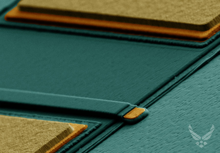 A false-color, plan-view SEM image of a lateral gallium oxide field effect transistor with an optically defined gate. From near (bottom) to far (top): the source, gate, and drain electrodes. Metal is shown in yellow and orange, dark blue represents dielectric material, and lighter blue denotes the gallium oxide substrate. Credit: AFRL Sensors Directorate at WPAFB, Ohio, U.S.