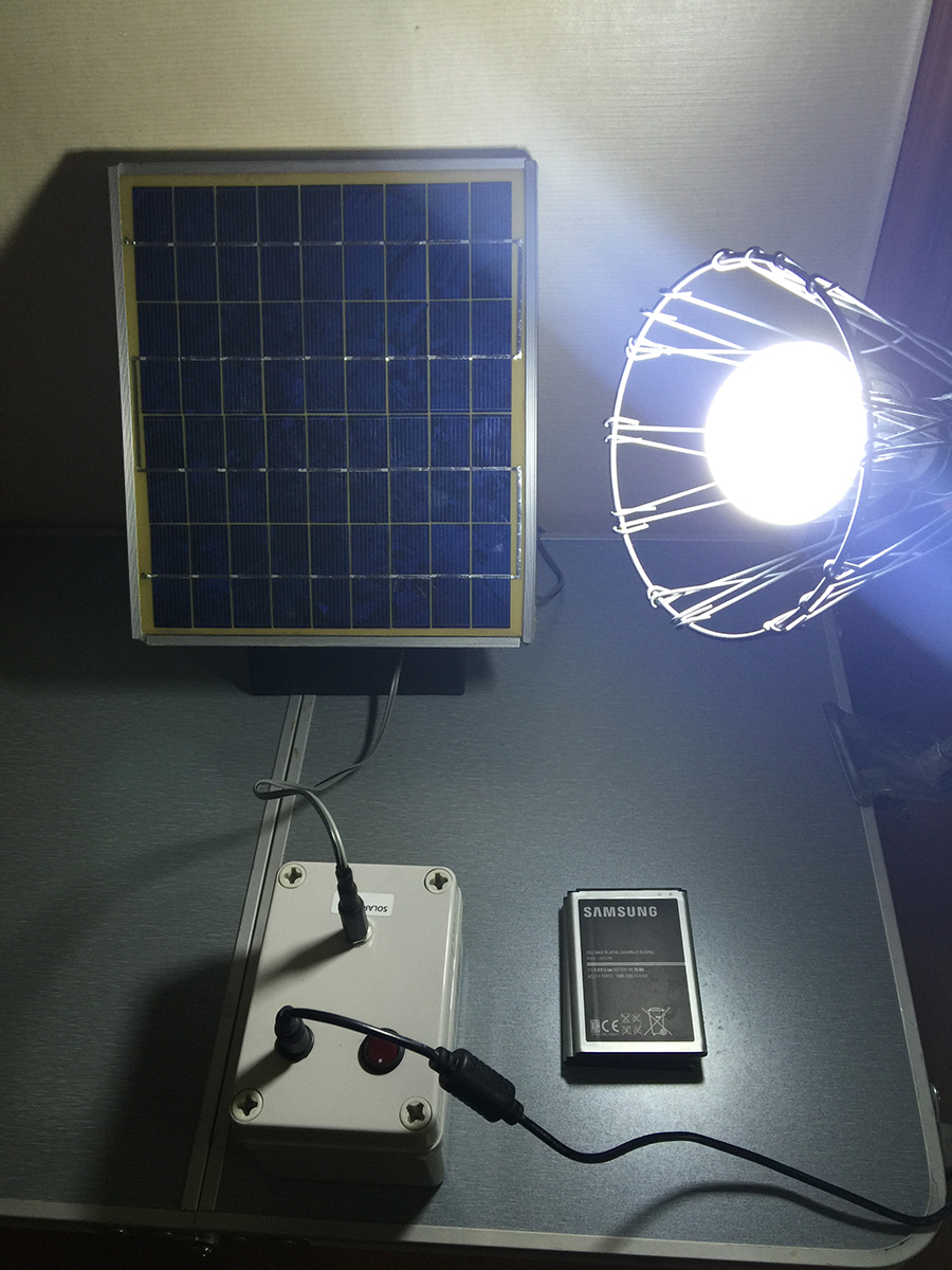 The prototype system consisting of a solar panel and 12V LED lamp wired to a battery pack containing three Samsung Galaxy Note 2 batteries. CREDIT - Diouf/Kyung Hee University