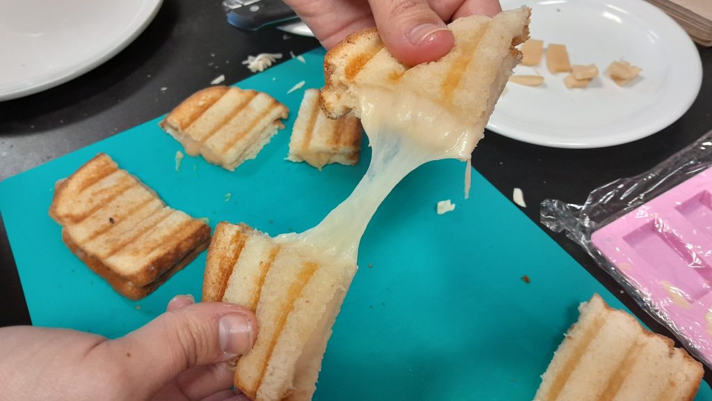 Researcher Alejandro Marangoni demonstrates the stretchy properties of his team’s plant-based cheese analog. Credit: Alejandro Marangoni 