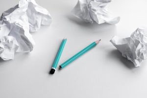 Broken pencil surrounded by crumpled paper, symbolizing revisions during grant writing