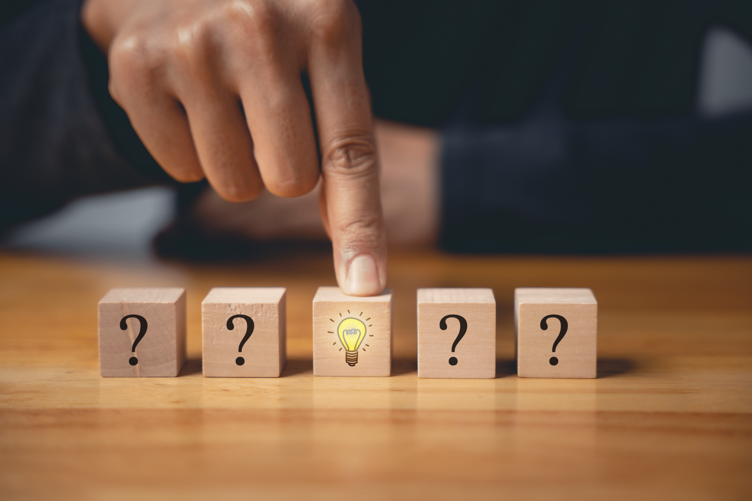 Finger pointing to a highlighted block among question marks