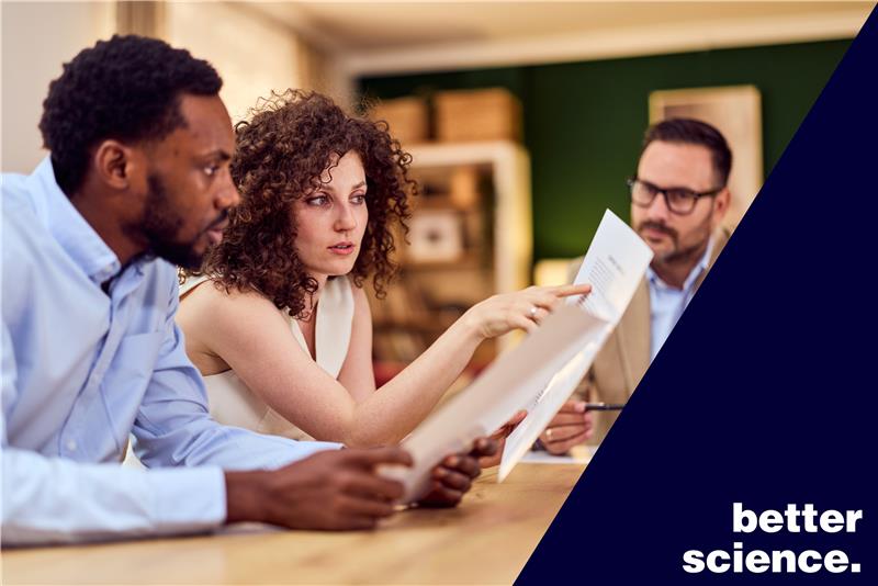 Group of professionals examining a document in a collaborative meeting.