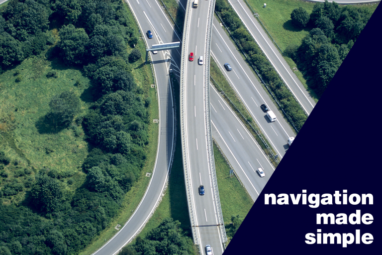 Aerial view of intersecting highways surrounded by greenery with the text “navigation made simple.”